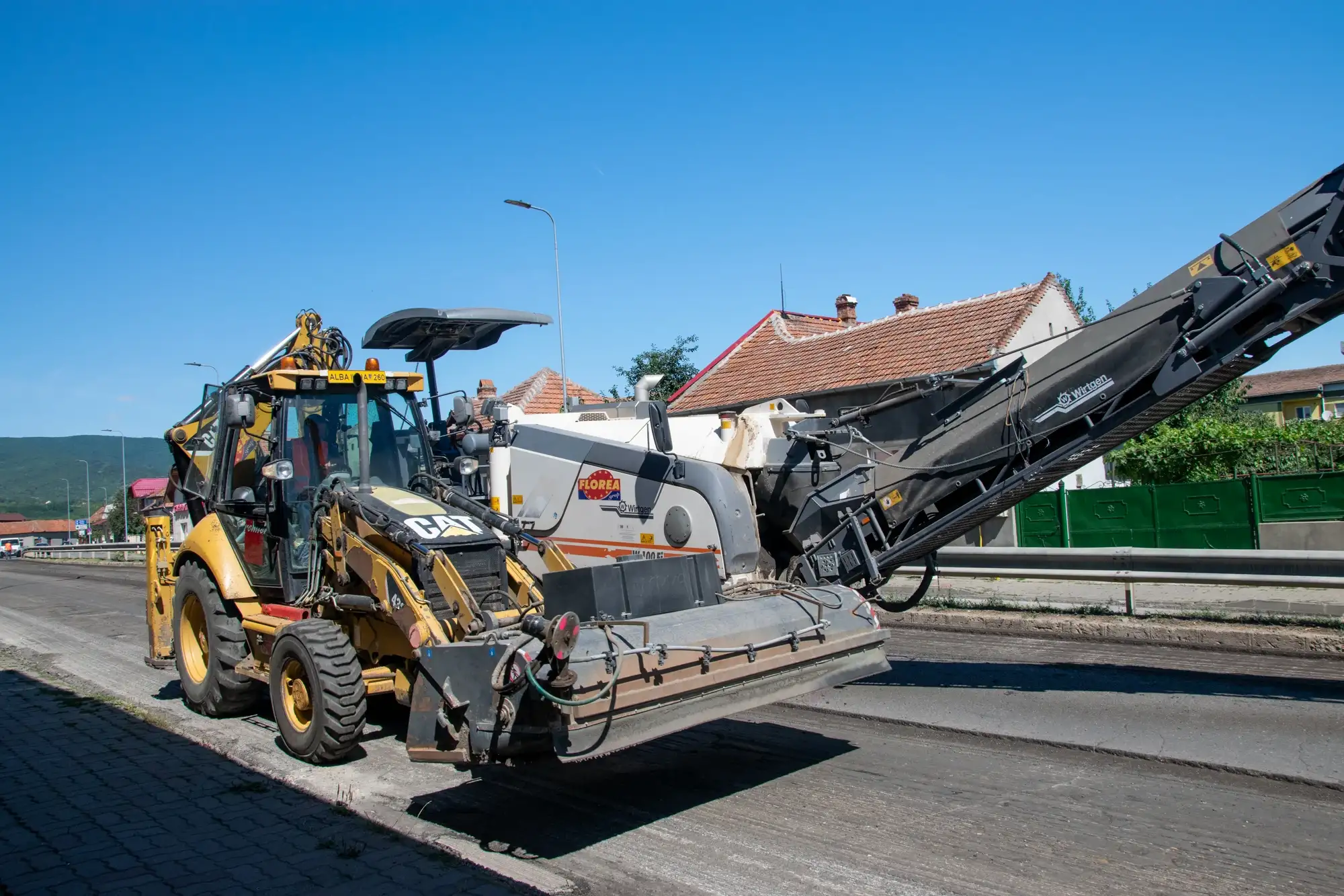 Încărcător și freză Wirtgen la lucrări de frezare a asfaltului pe un drum urban