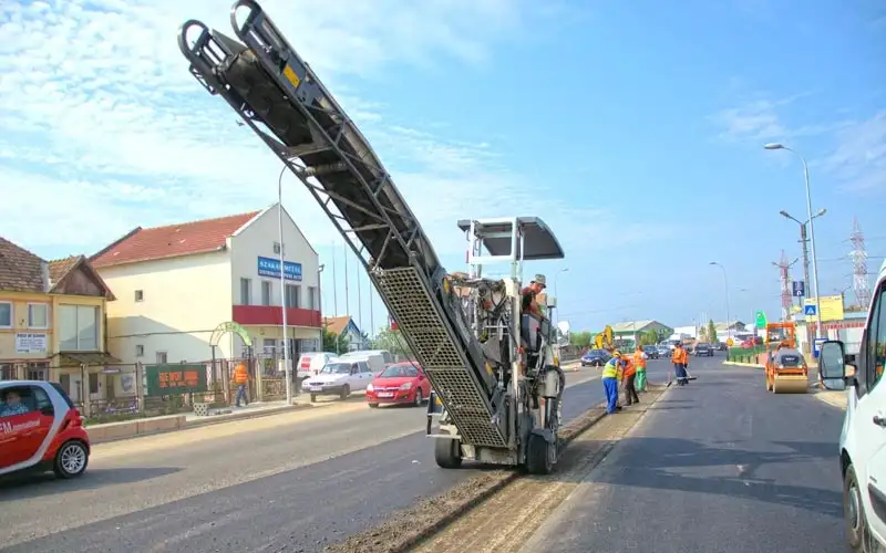 Freză rutieră cu bandă transportoare pe un drum în reabilitare