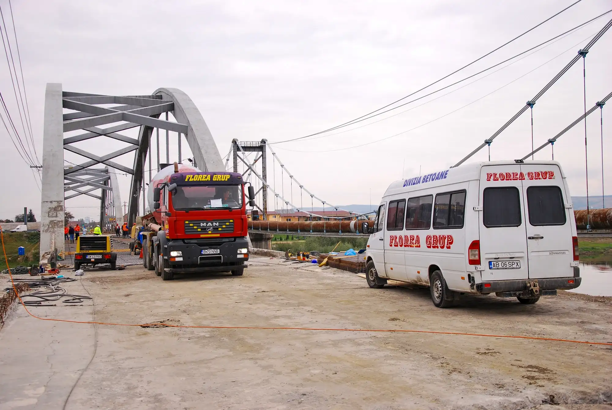 Camion și autoutilitară Florea Grup pe un pod în arc aflat în construcție