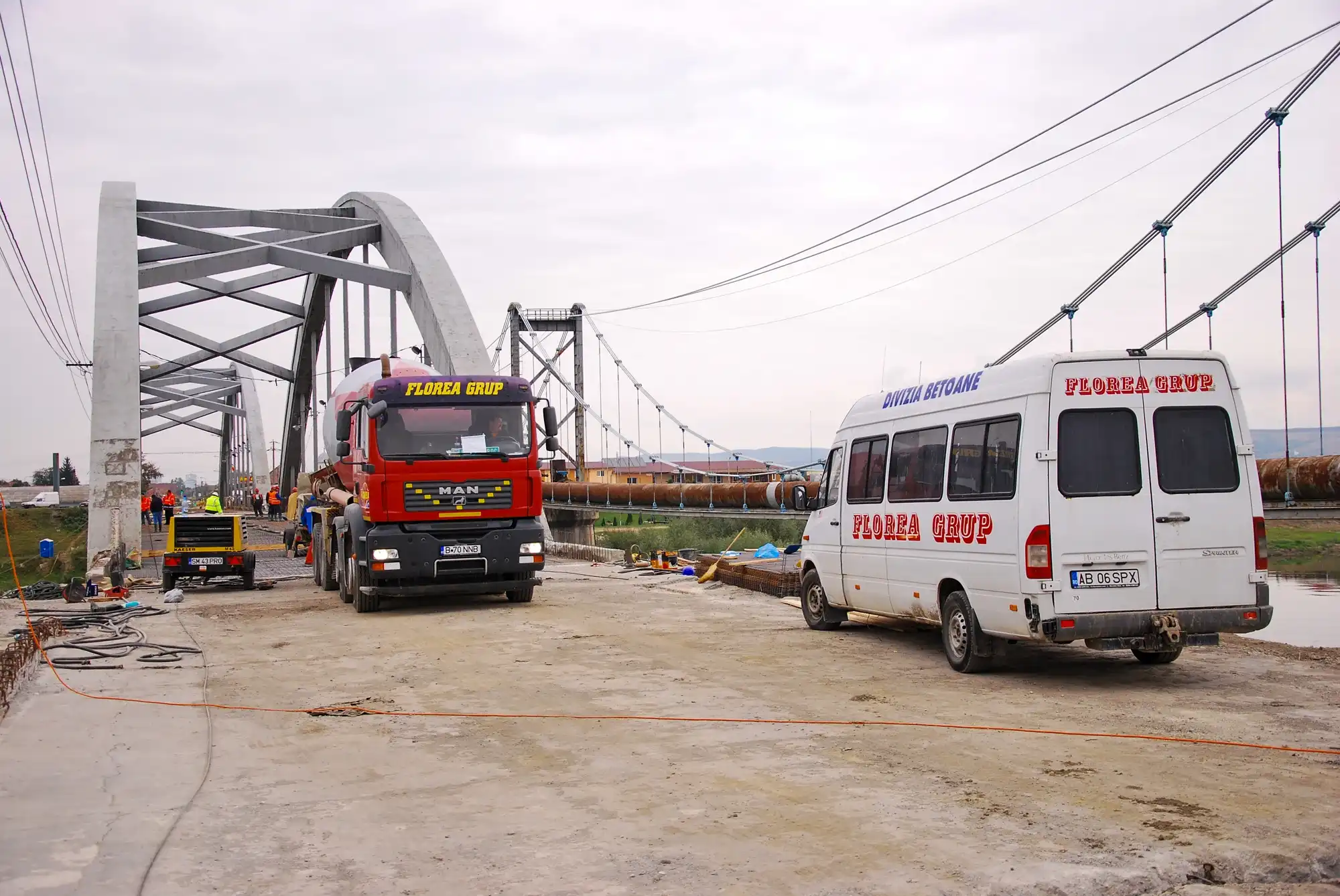 Camion și autoutilitară Florea Grup pe un pod în arc aflat în construcție