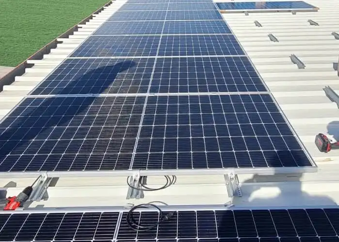 Panouri fotovoltaice montate pe acoperișul unei hale industriale