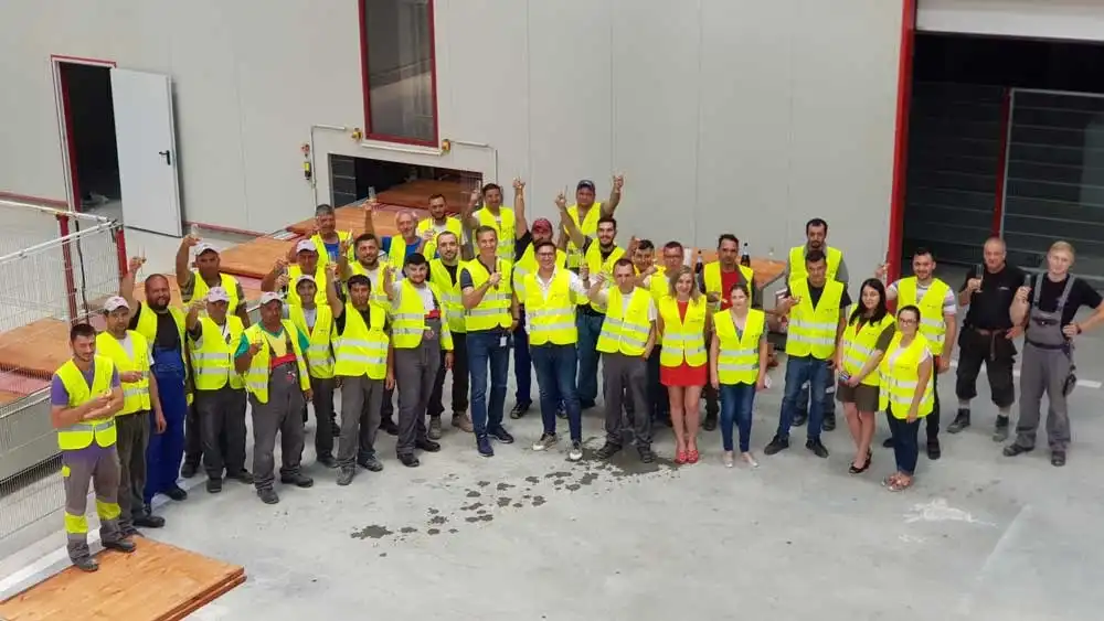 Echipa Florea Grup în veste reflectorizante, într-o hală de producție