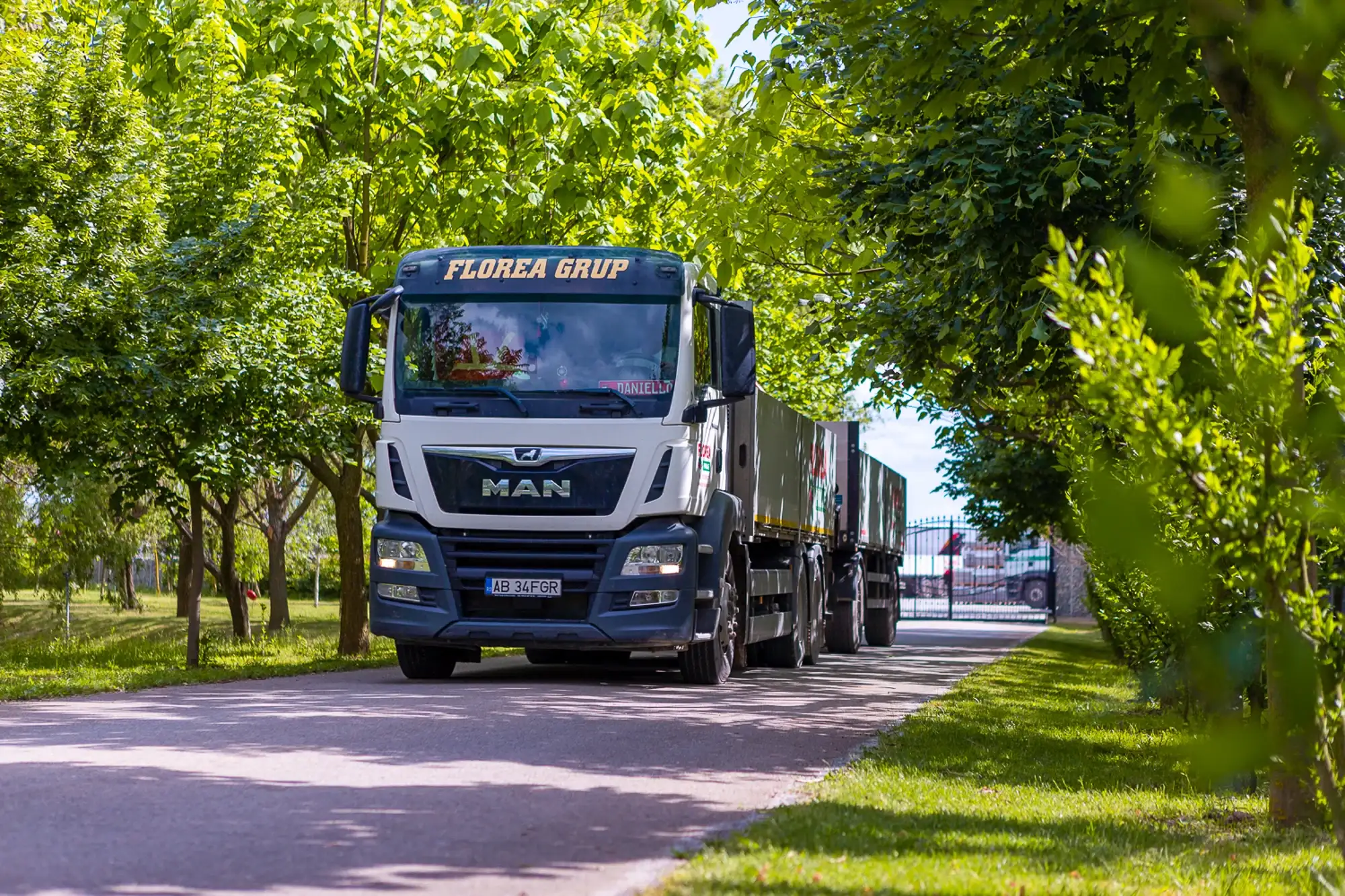 Camion MAN Florea Grup pe o alee cu copaci